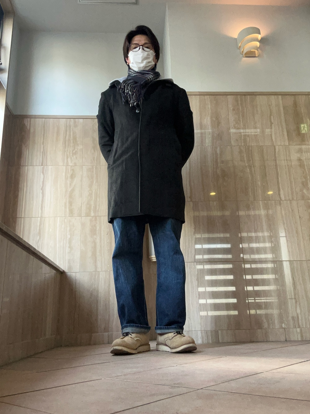 グレー系のニット/セーター、グレー系のパーカー、ブルー系のデニムパンツを着用したメンズの冬コーディネートの2枚目の写真