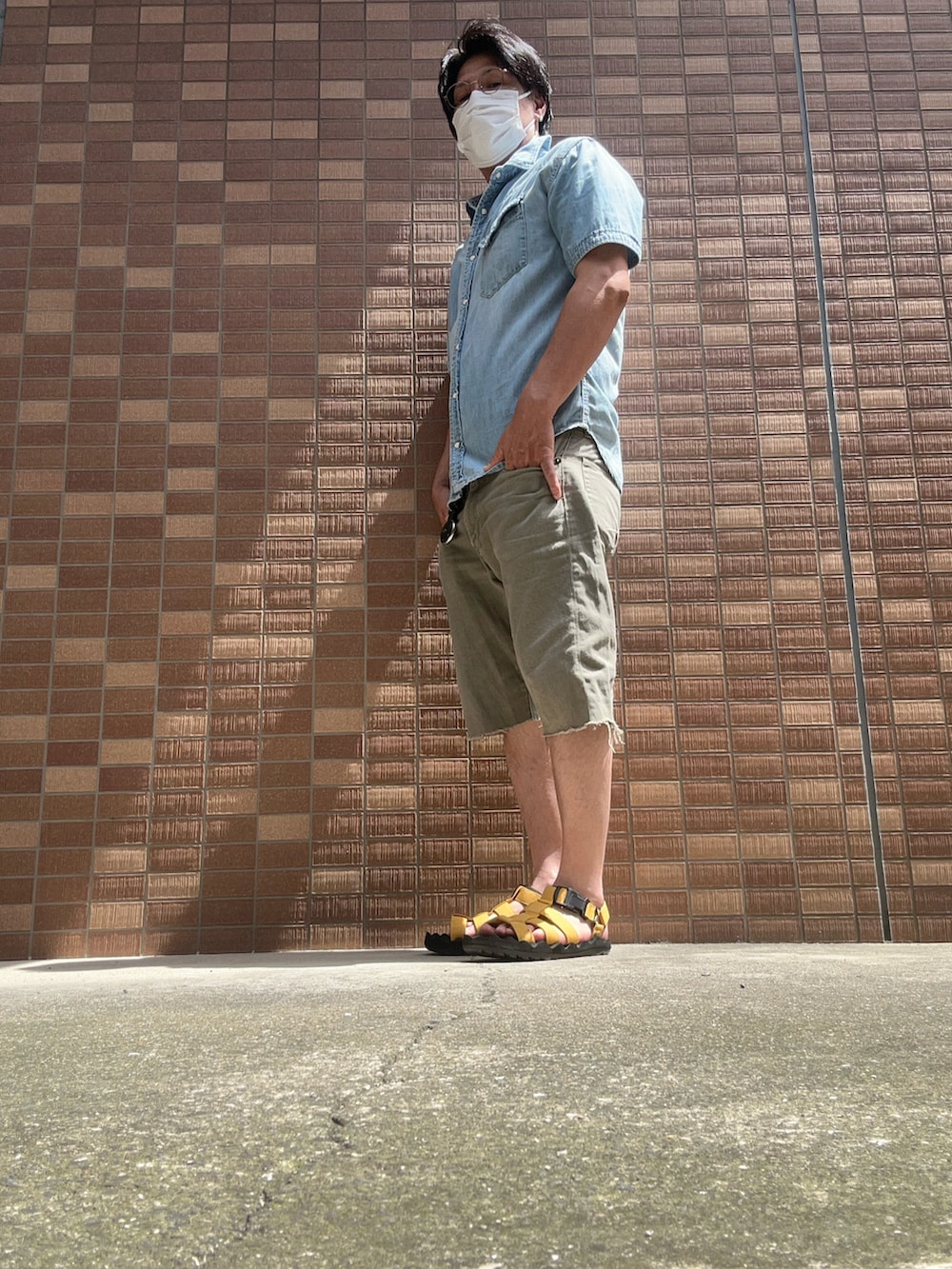 ブルー系のトップス、グリーン系のその他パンツ、イエロー系のサンダルを着用したメンズの夏コーディネートの2枚目の写真
