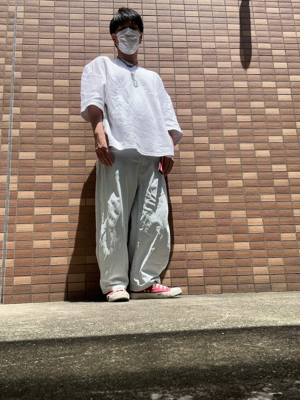 ホワイト系のTシャツ/カットソー、ブルー系のデニムパンツ、レッド系のスニーカーを着用したメンズの春コーディネートの2枚目の写真