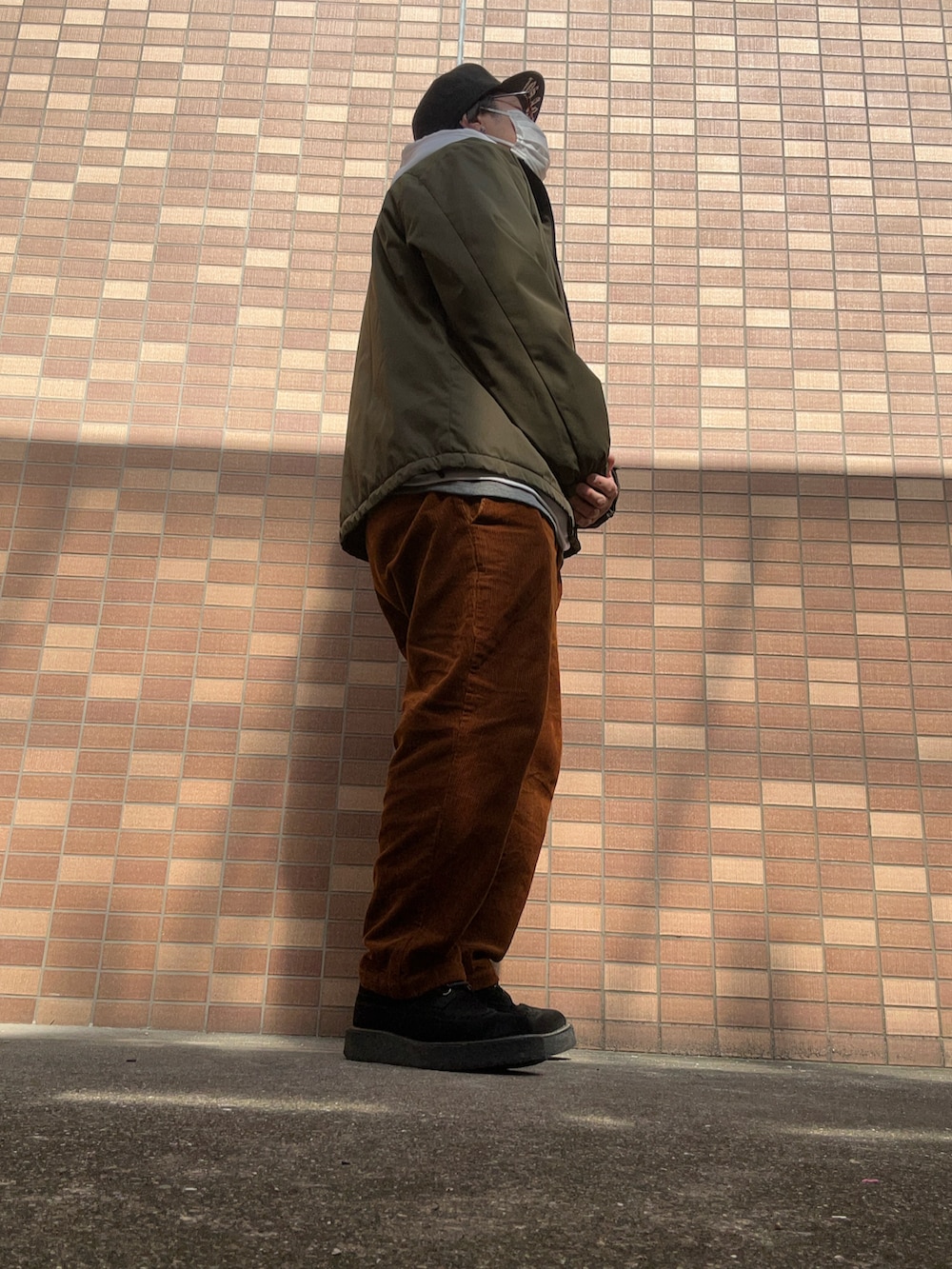 ホワイト系のパーカー、ブラウン系のパンツ、ブラック系のその他シューズを着用したメンズの春コーディネートの3枚目の写真