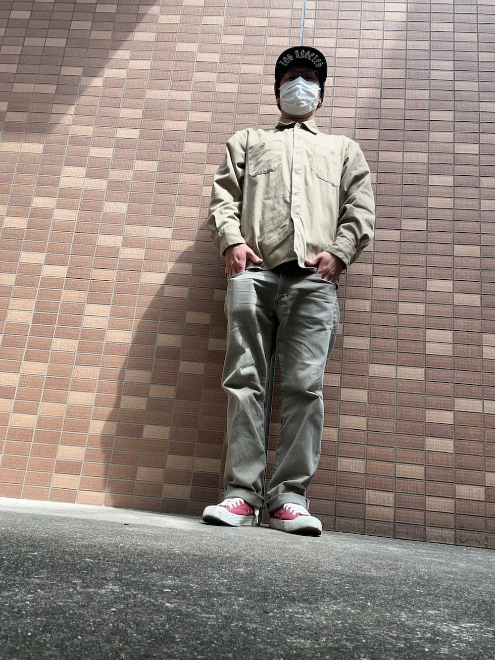 ブラウン系のスラックス、レッド系のスニーカー、ブルー系のスウェットを着用したメンズの春コーディネートの2枚目の写真