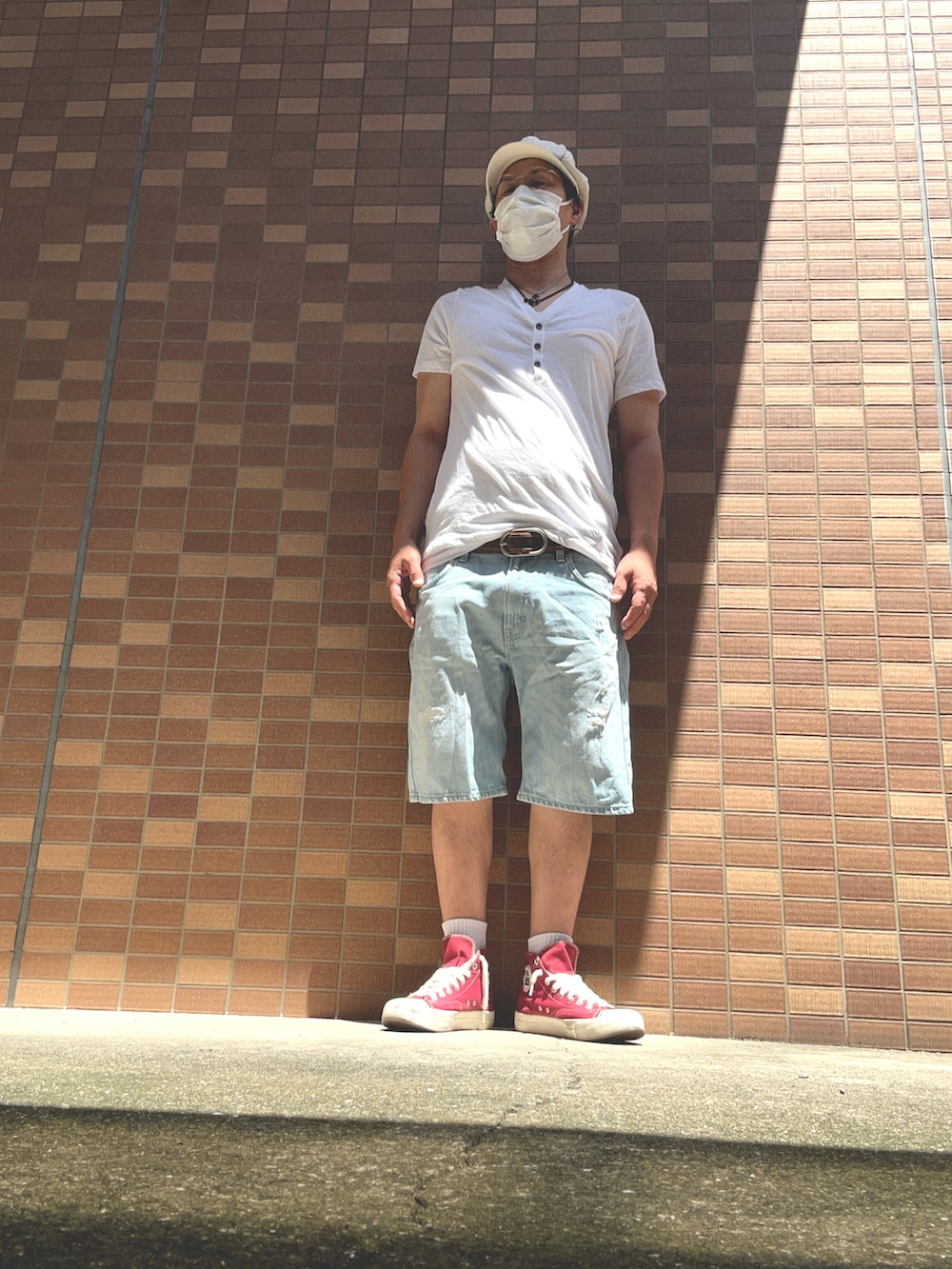 ブルー系のデニムパンツ、レッド系のスニーカー、ホワイト系のTシャツ/カットソーを着用したメンズの夏コーディネートの2枚目の写真