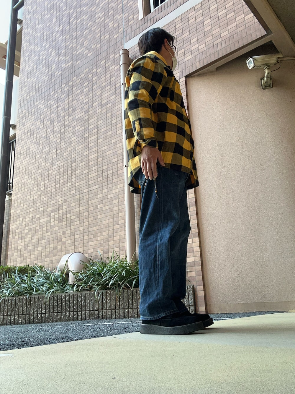 ブルー系のデニムパンツ、ブラック系のシューズ、イエロー系のシャツ/ブラウスを着用したメンズの冬コーディネートの2枚目の写真