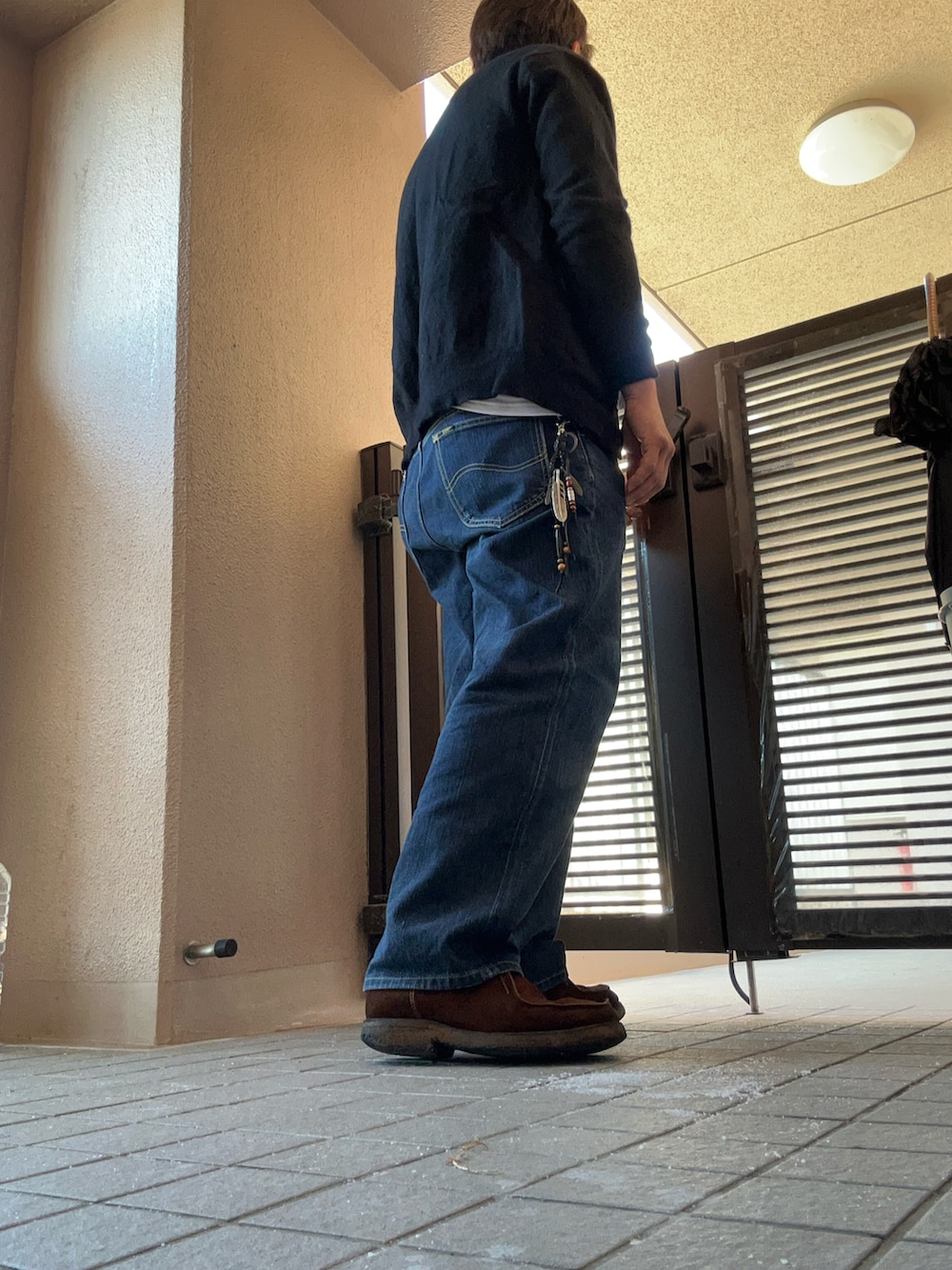 ホワイト系のTシャツ/カットソー、ブラック系のカーディガン/ボレロ、ブラウン系のブーツを着用したメンズの秋コーディネートの2枚目の写真