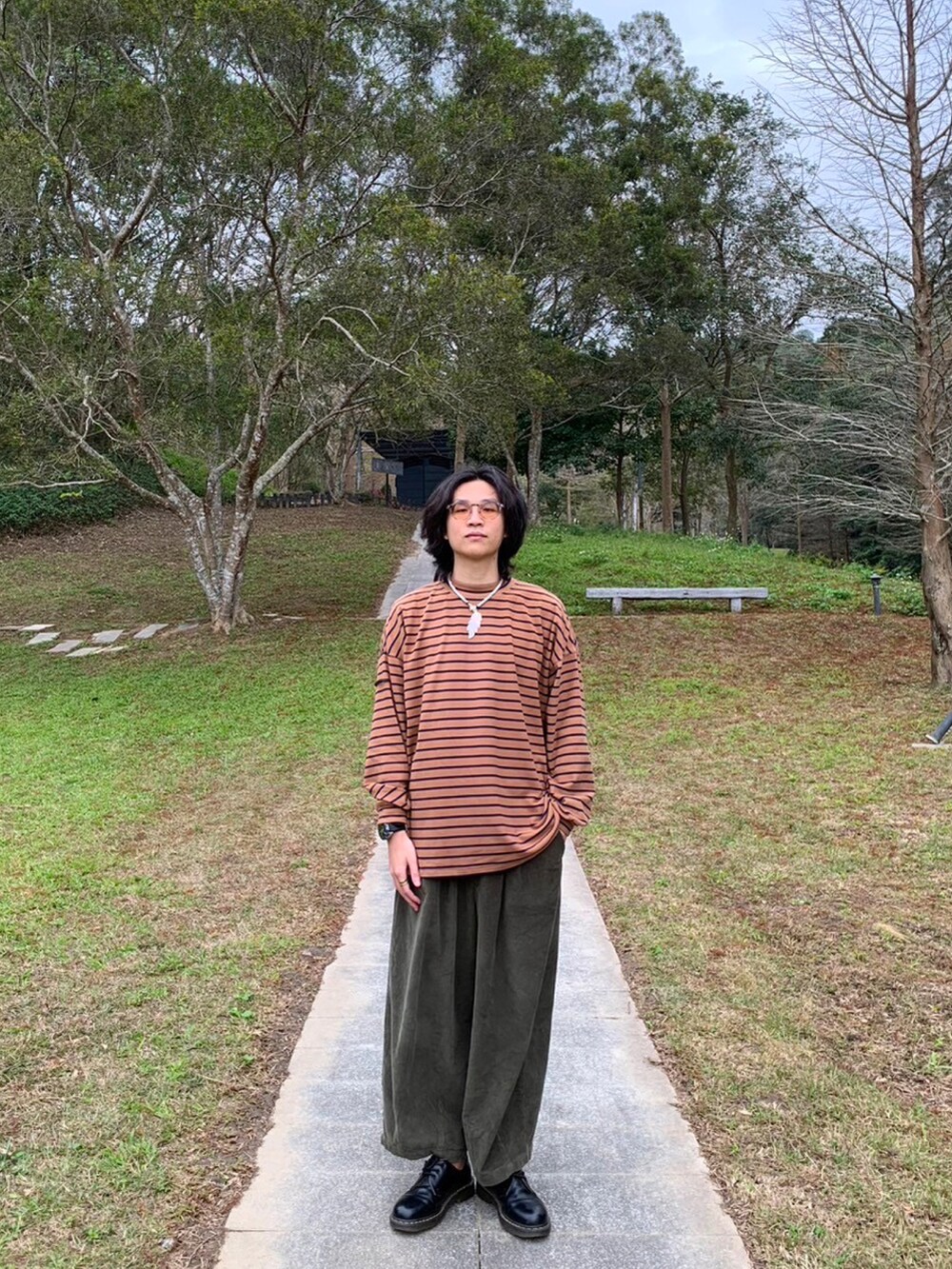 グリーン系のその他パンツ、ブラウン系のダウンベスト、オレンジ系のトップスを着用したメンズの冬コーディネートの3枚目の写真