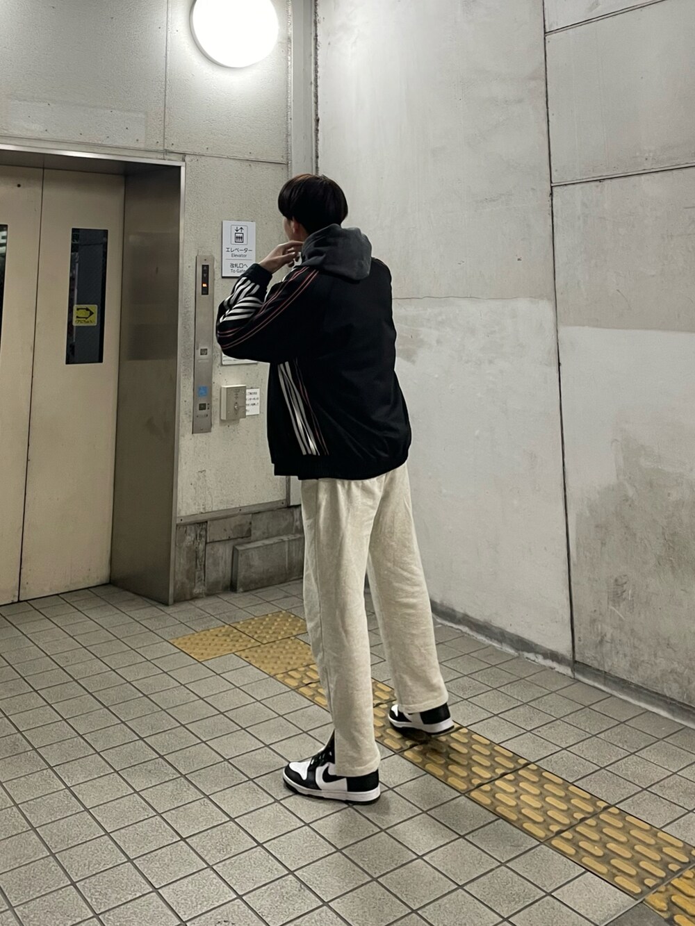 ブラック系のスニーカー、グレー系のスウェットパンツ、ブラック系のパーカーを着用したメンズの冬コーディネートの3枚目の写真