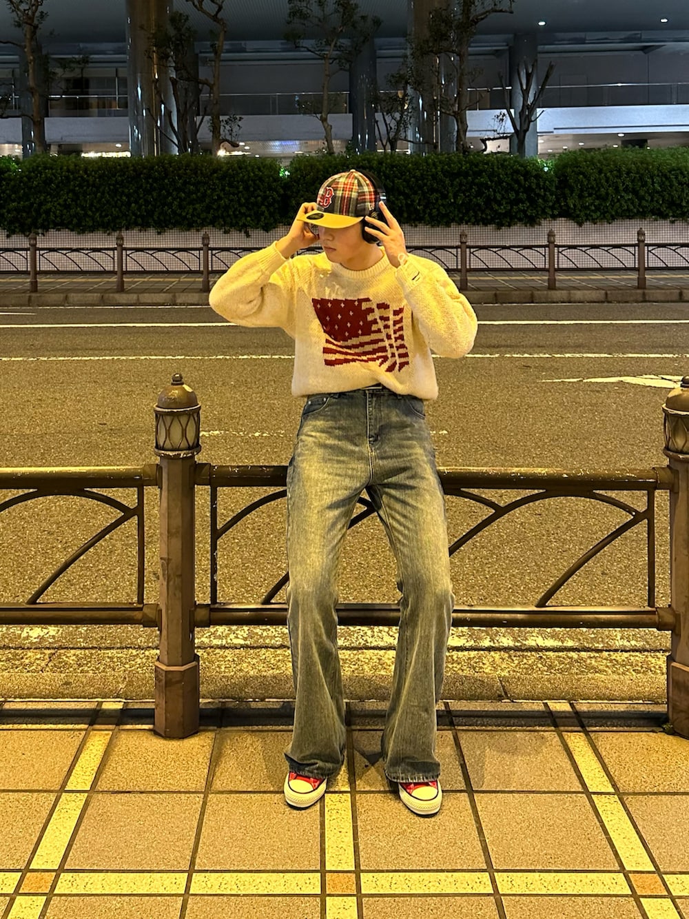 レッド系のスニーカー、ブルー系のデニムパンツ、ホワイト系のニット/セーターを着用したメンズの冬コーディネートの2枚目の写真