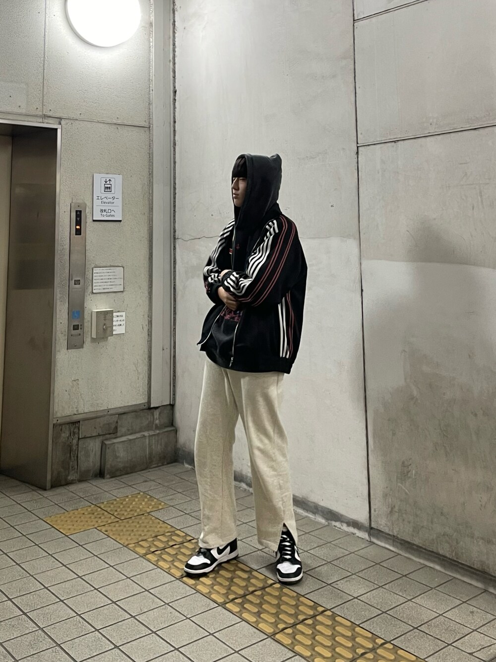 ブラック系のスニーカー、グレー系のスウェットパンツ、ブラック系のパーカーを着用したメンズの冬コーディネートの4枚目の写真