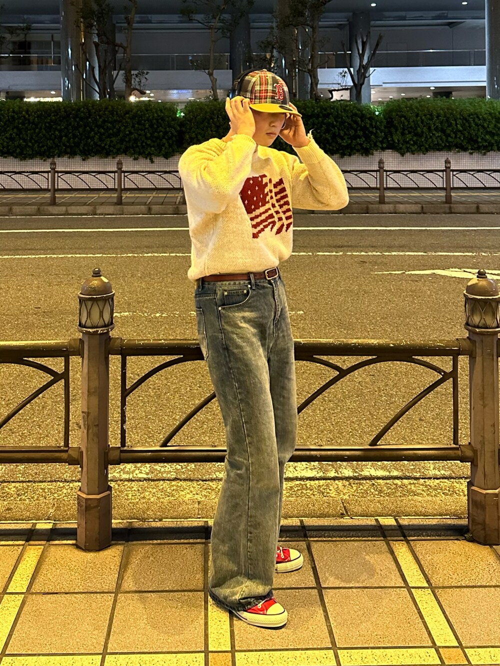 レッド系のスニーカー、ブルー系のデニムパンツ、ホワイト系のニット/セーターを着用したメンズの冬コーディネートの3枚目の写真