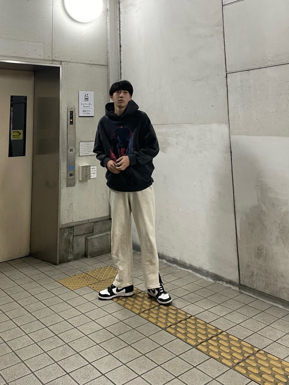 ブラック系のスニーカー、グレー系のスウェットパンツ、ブラック系のパーカーを着用したメンズの冬コーディネートの2枚目の写真