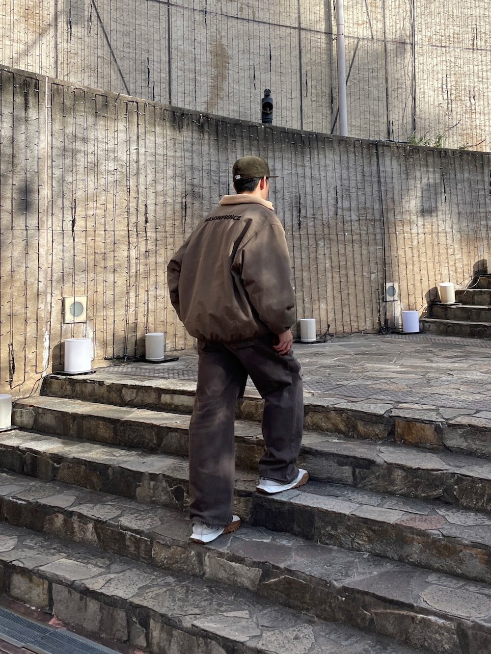 ホワイト系のスニーカー、ブラウン系のデニムパンツ、オレンジ系のシャツ/ブラウスを着用したメンズの冬コーディネートの2枚目の写真