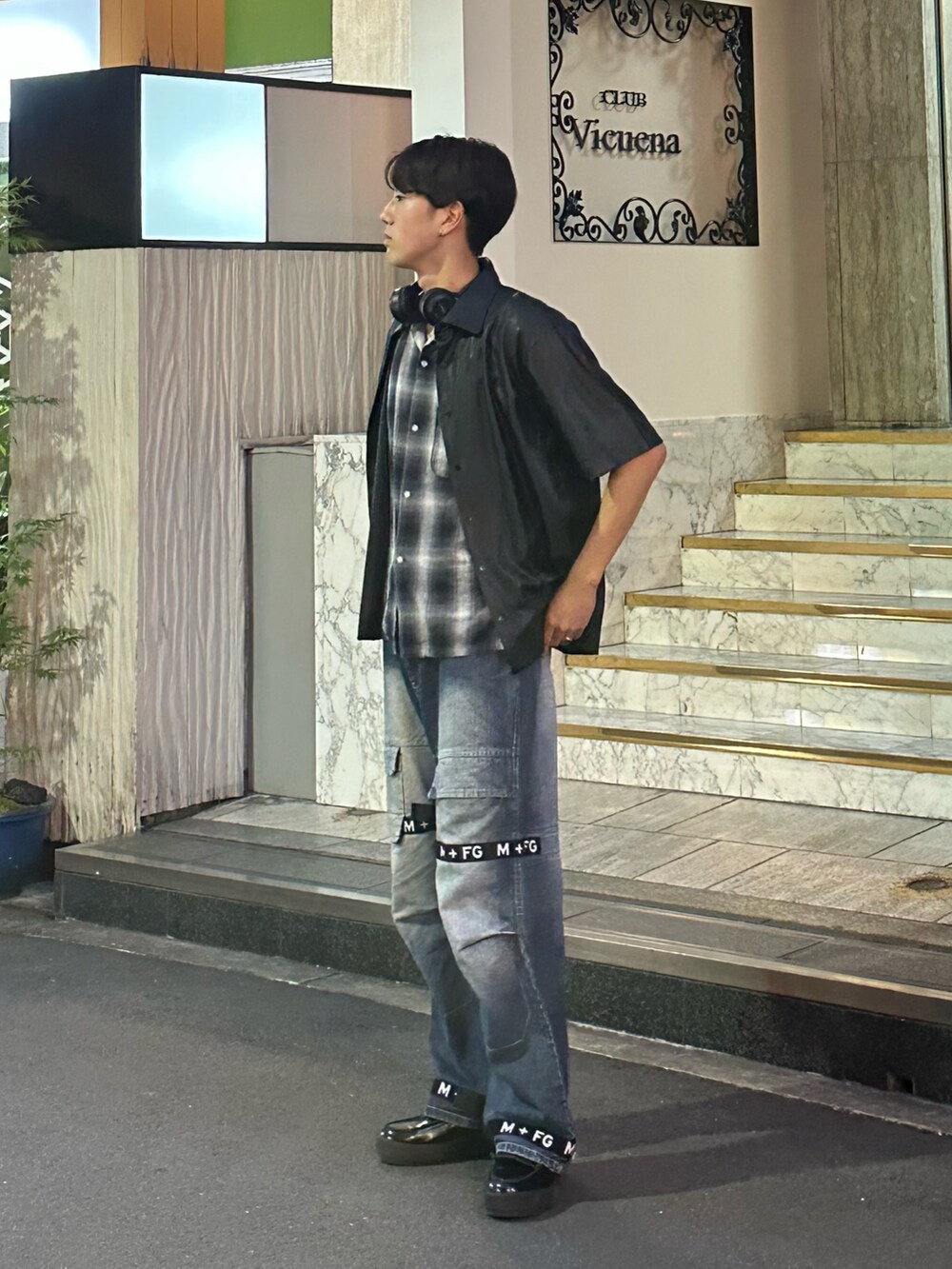 ブラック系のローファー、ブルー系のデニムパンツ、ブラック系のその他アウターを着用したメンズの夏コーディネートの2枚目の写真