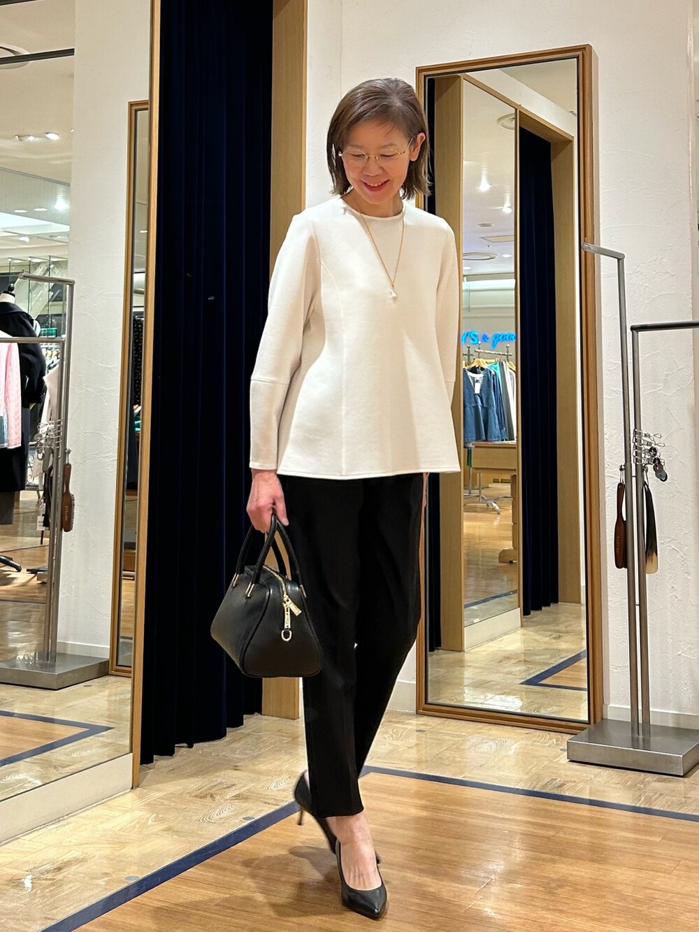 ブラック系のその他パンツ、ブラック系のショルダーバッグ、ホワイト系のTシャツ/カットソーを着用したレディースの冬コーディネートの6枚目の写真