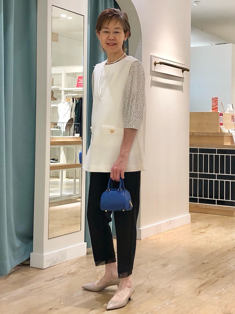 ホワイト系のベスト、ブラック系のその他パンツ、ホワイト系のTシャツ/カットソーを着用したレディースの夏コーディネートの4枚目の写真