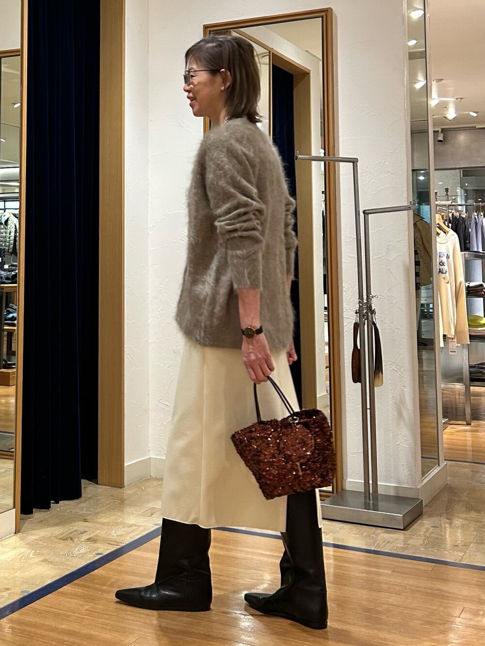 ホワイト系のスカート、ブラウン系のショルダーバッグ、ブラウン系のカーディガン/ボレロを着用したレディースの冬コーディネートの6枚目の写真