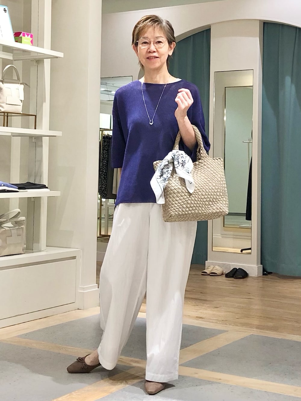 ホワイト系のその他パンツ、パープル系のニット/セーター、シルバー系のネックレスを着用したレディースの春コーディネートの2枚目の写真