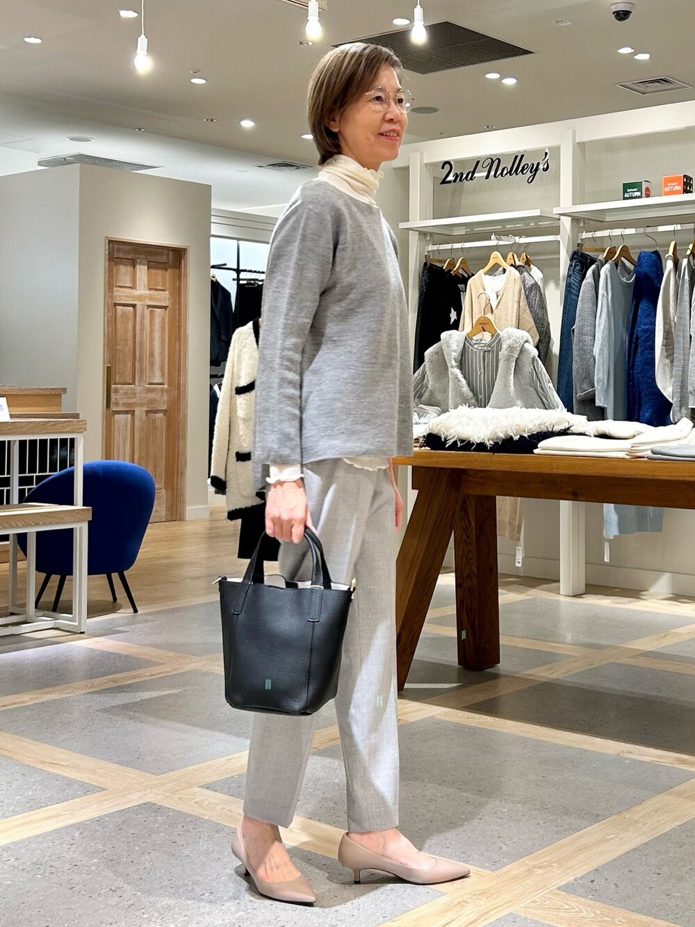 グレー系のその他パンツ、ブラック系のトートバッグ、グレー系のニット/セーターを着用したレディースの秋コーディネートの4枚目の写真