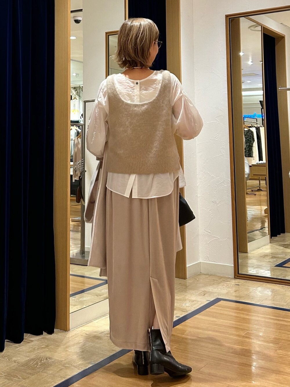 ベージュ系のスカート、ピンク系のダッフルコート、ブラック系のショルダーバッグを着用したレディースの秋コーディネートの7枚目の写真