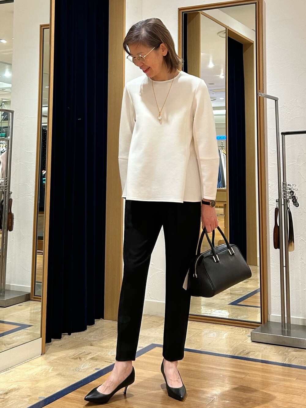 ブラック系のその他パンツ、ブラック系のショルダーバッグ、ホワイト系のTシャツ/カットソーを着用したレディースの冬コーディネートの2枚目の写真