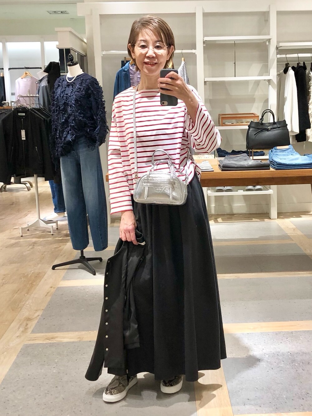 ブラック系のスカート、ブラック系のブルゾン、ホワイト系のTシャツ/カットソーを着用したレディースの秋コーディネートの5枚目の写真