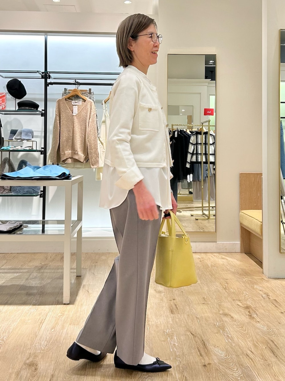 グレー系のその他パンツ、イエロー系のトートバッグ、ホワイト系のカーディガン/ボレロを着用したレディースの冬コーディネートの6枚目の写真