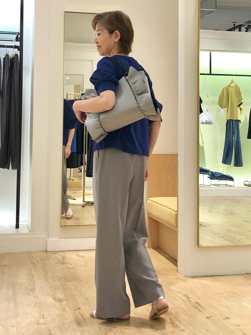 グレー系のその他パンツ、ブルー系のTシャツ/カットソー、グレー系のトートバッグを着用したレディースの夏コーディネートの4枚目の写真