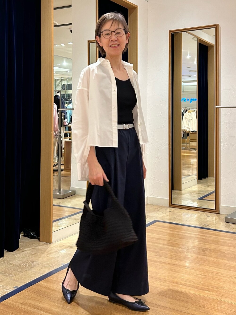 ブルー系のその他パンツ、ブラック系のショルダーバッグ、ブラック系のタンクトップを着用したレディースの春コーディネートの2枚目の写真