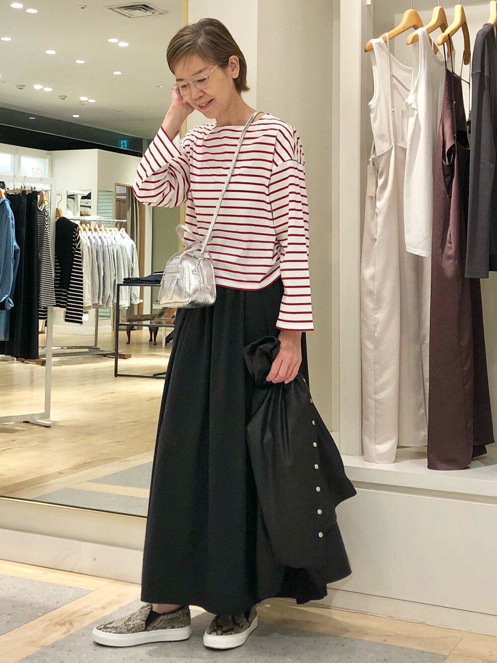 ブラック系のスカート、ブラック系のブルゾン、ホワイト系のTシャツ/カットソーを着用したレディースの秋コーディネートの3枚目の写真