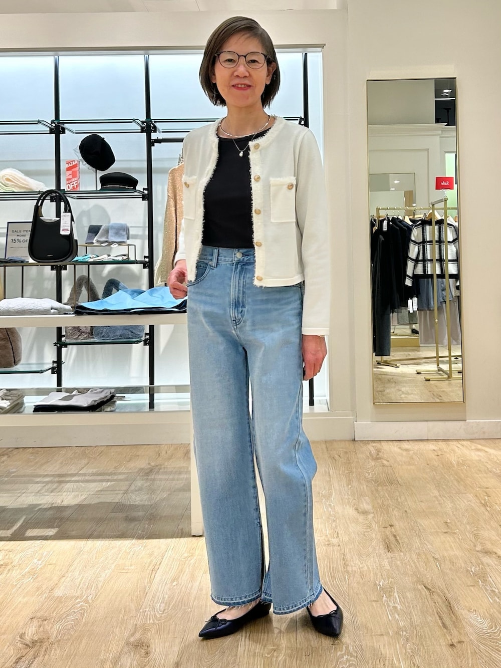 ブルー系のデニムパンツ、ホワイト系のカーディガン/ボレロ、グレー系のTシャツ/カットソーを着用したレディースの冬コーディネートの2枚目の写真