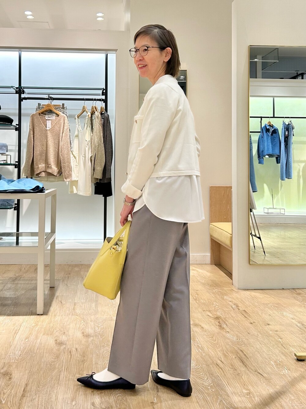グレー系のその他パンツ、イエロー系のトートバッグ、ホワイト系のカーディガン/ボレロを着用したレディースの冬コーディネートの5枚目の写真