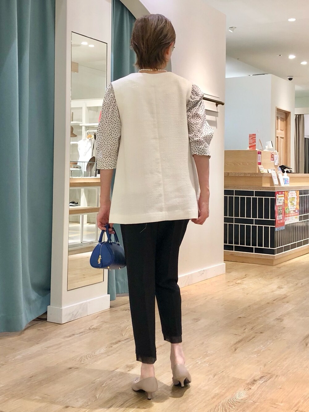 ホワイト系のベスト、ブラック系のその他パンツ、ホワイト系のTシャツ/カットソーを着用したレディースの夏コーディネートの5枚目の写真