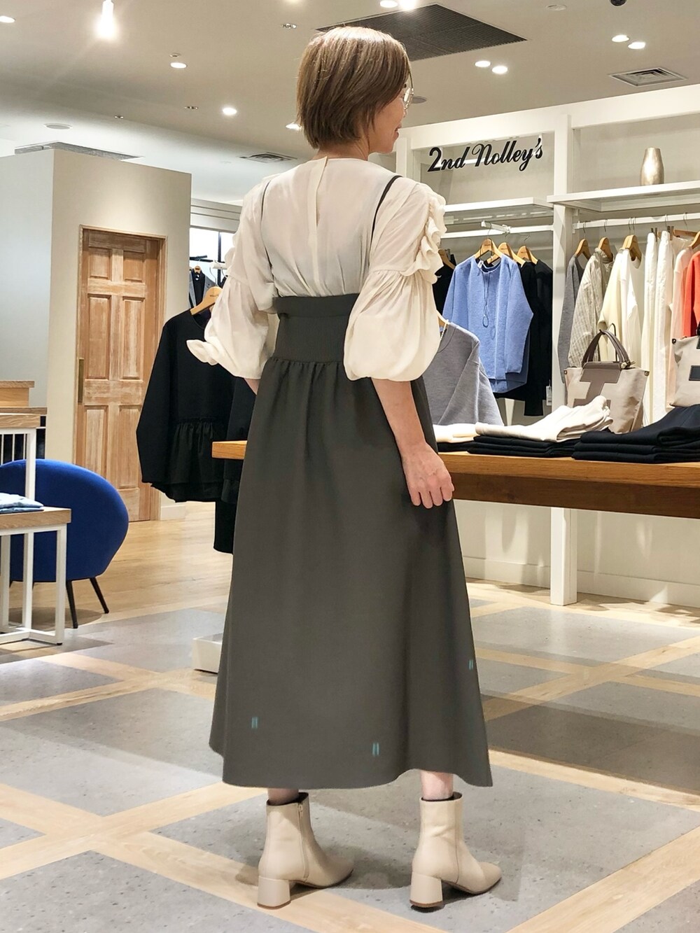 ホワイト系のシャツ/ブラウス、グレー系のスカート、ブラック系のブルゾンを着用したレディースの秋コーディネートの6枚目の写真