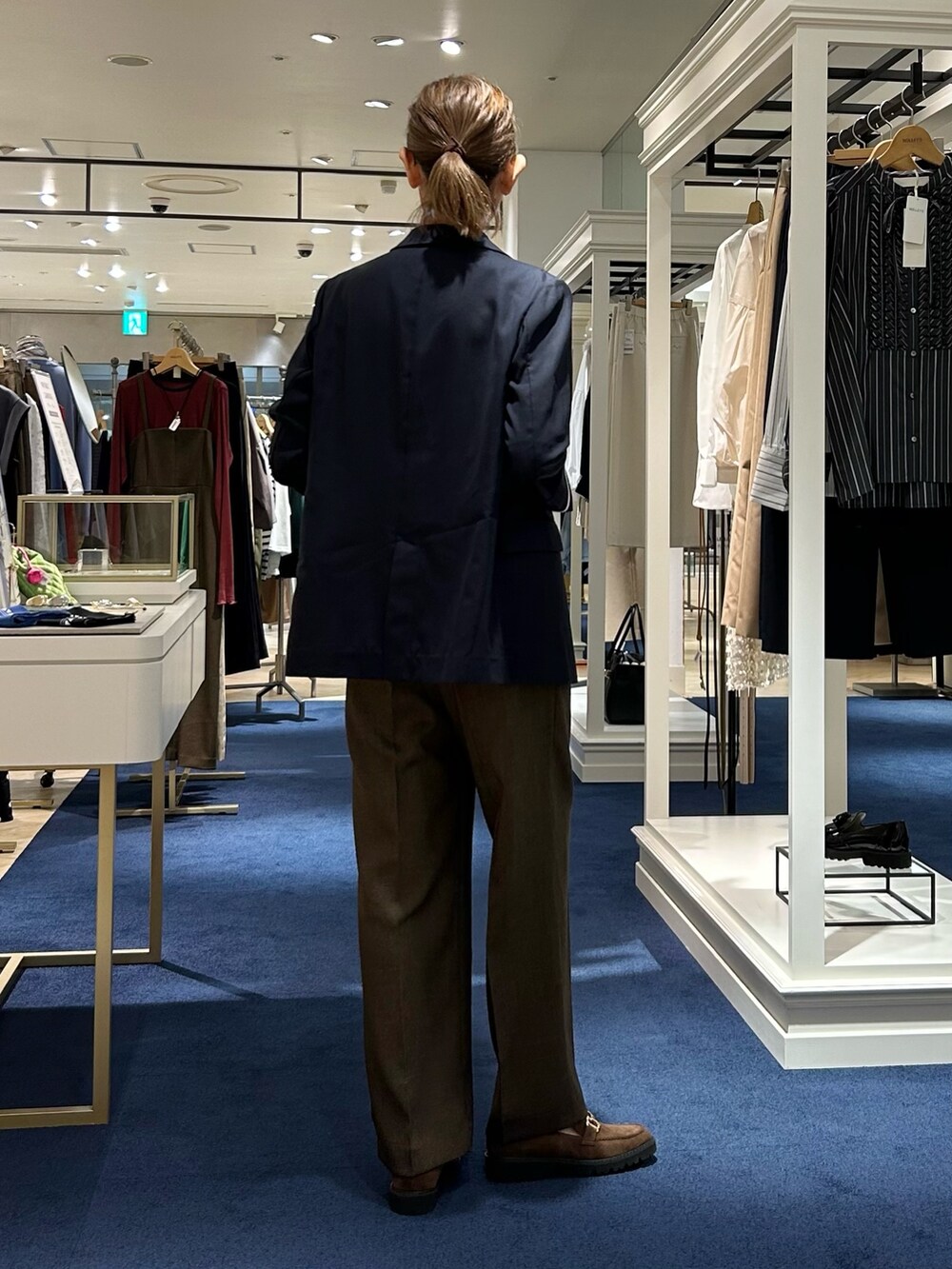 ブラウン系のその他パンツ、ブルー系のテーラードジャケット、グリーン系のニット/セーターを着用したレディースの秋コーディネートの5枚目の写真