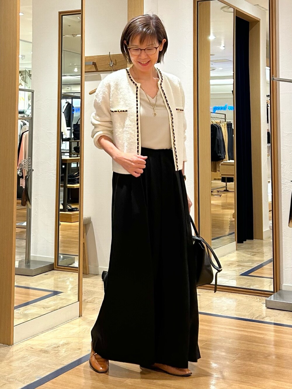 ブラック系のその他パンツ、ブラック系のショルダーバッグ、ホワイト系のカーディガン/ボレロを着用したレディースの秋コーディネートの3枚目の写真