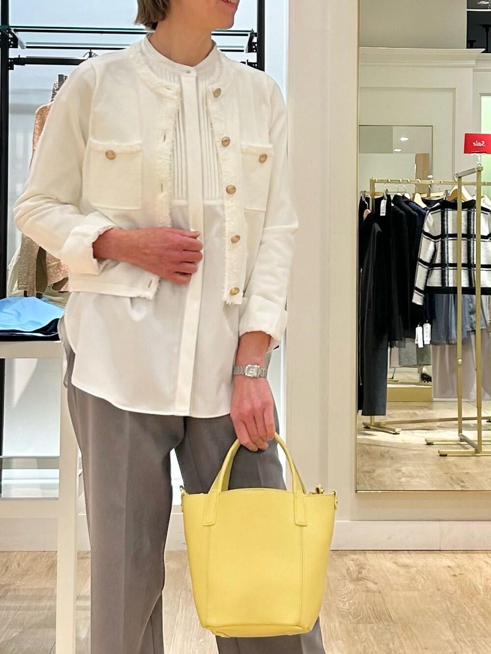 グレー系のその他パンツ、イエロー系のトートバッグ、ホワイト系のカーディガン/ボレロを着用したレディースの冬コーディネートの4枚目の写真