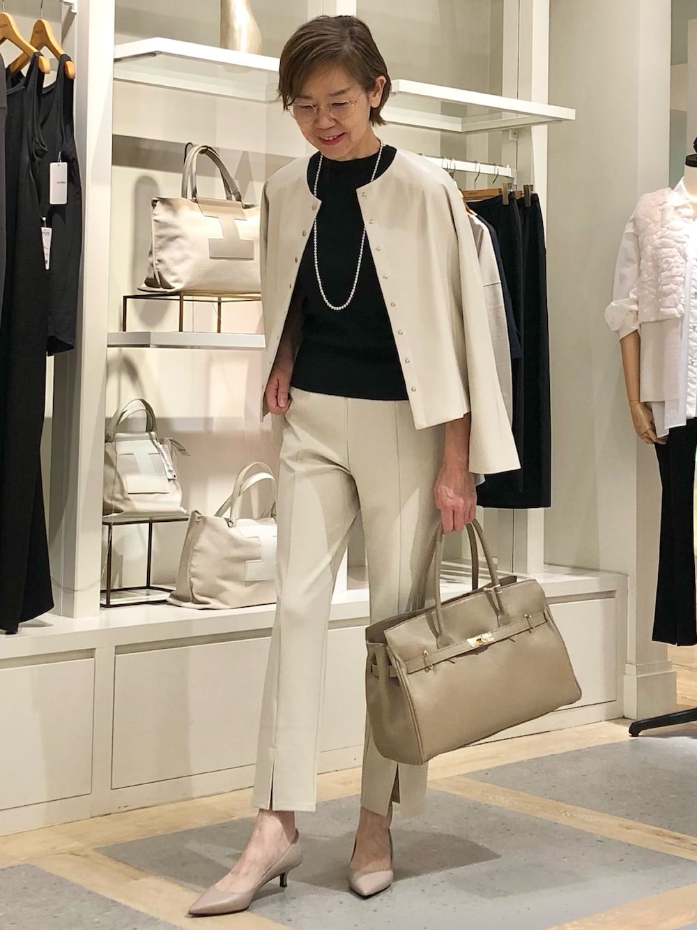 ベージュ系のその他パンツ、ベージュ系のブルゾン、ブラック系のニット/セーターを着用したレディースの秋コーディネートの2枚目の写真