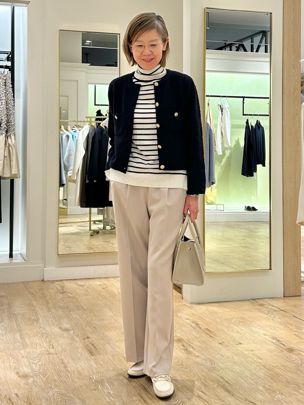 ベージュ系のその他パンツ、ホワイト系のニット/セーター、ブルー系のカーディガン/ボレロを着用したレディースの冬コーディネートの3枚目の写真