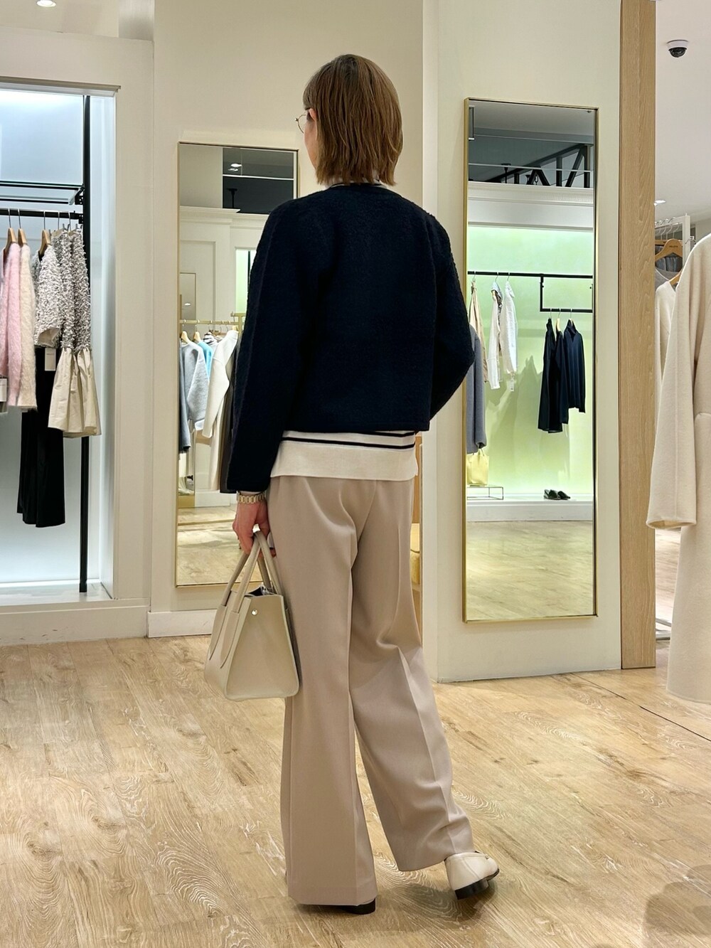 ベージュ系のその他パンツ、ホワイト系のニット/セーター、ブルー系のカーディガン/ボレロを着用したレディースの冬コーディネートの6枚目の写真