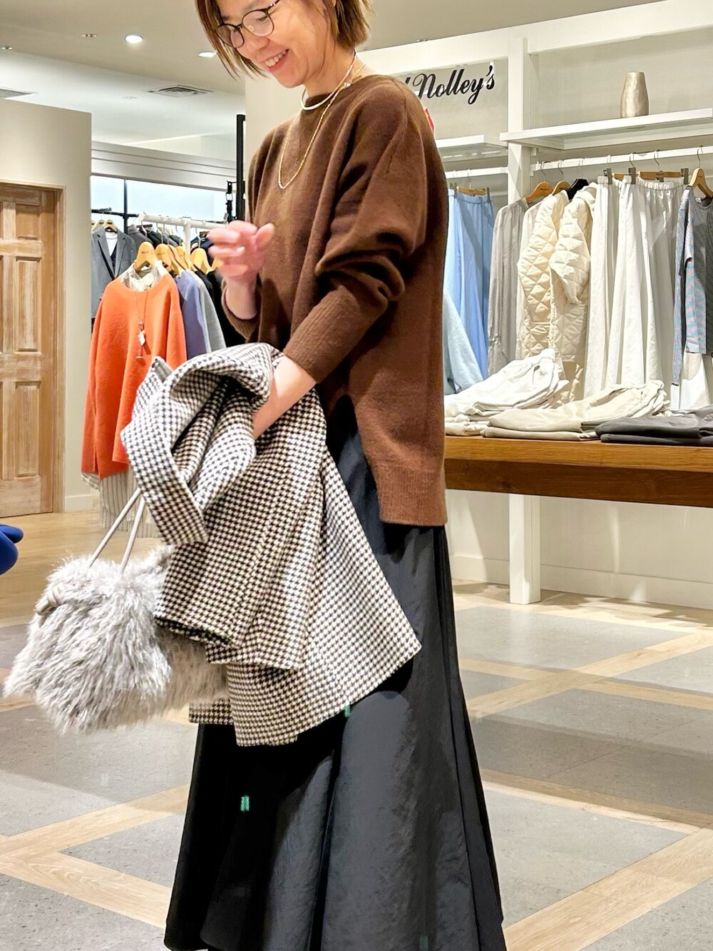 ブラック系のスカート、グレー系のショルダーバッグ、ベージュ系のチェスターコートを着用したレディースの冬コーディネートの5枚目の写真