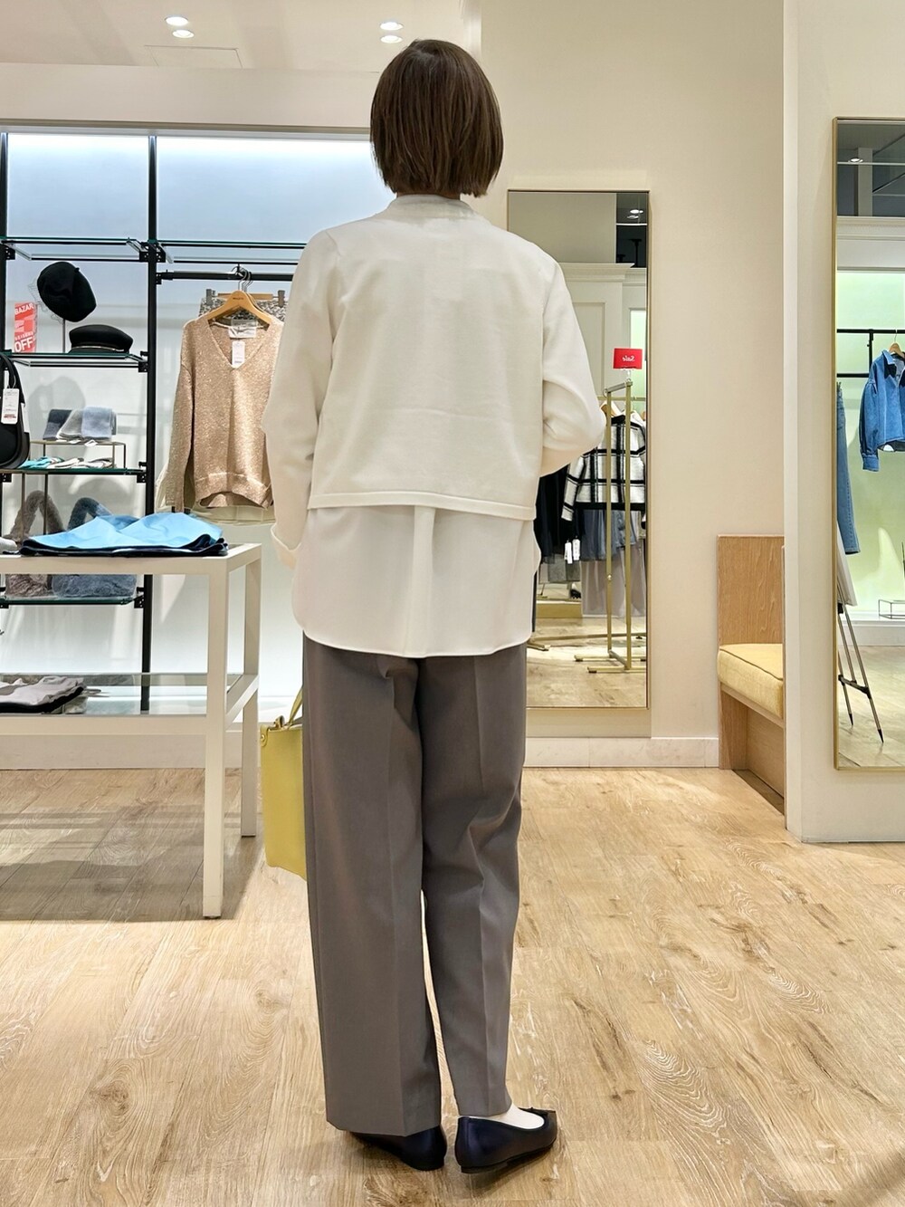 グレー系のその他パンツ、イエロー系のトートバッグ、ホワイト系のカーディガン/ボレロを着用したレディースの冬コーディネートの7枚目の写真