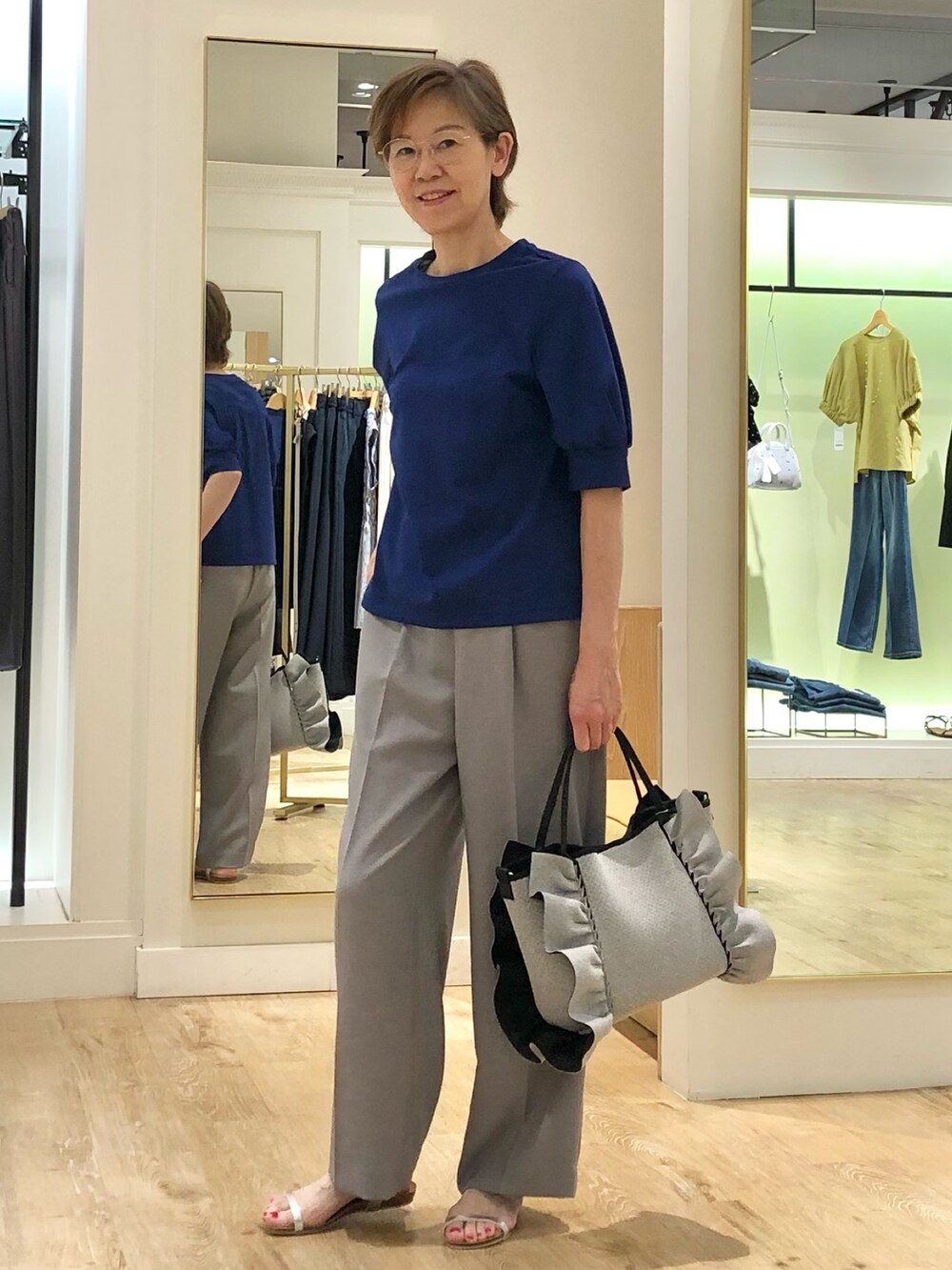 グレー系のその他パンツ、ブルー系のTシャツ/カットソー、グレー系のトートバッグを着用したレディースの夏コーディネートの3枚目の写真