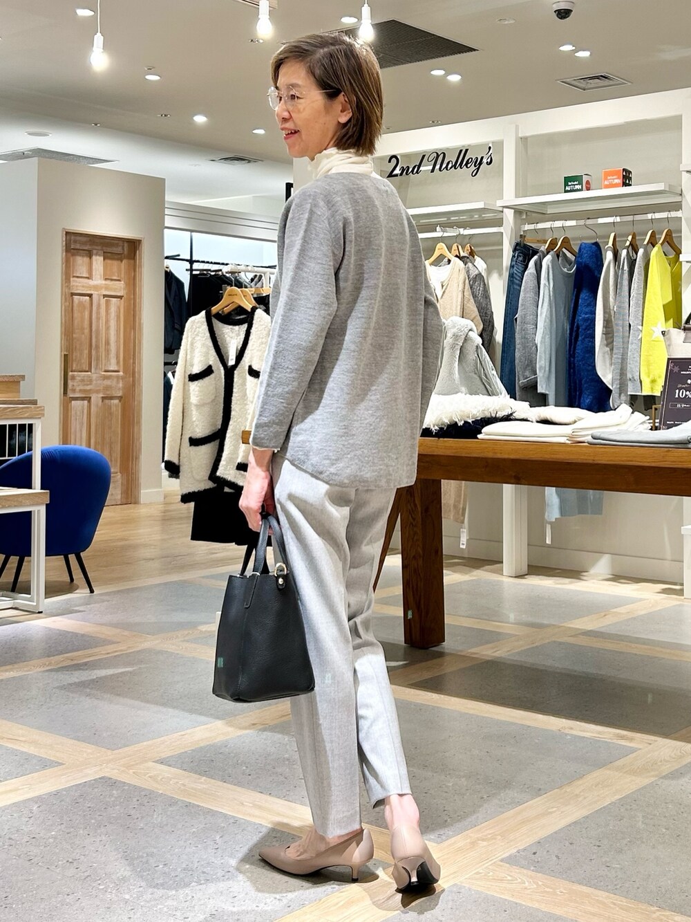 グレー系のその他パンツ、ブラック系のトートバッグ、グレー系のニット/セーターを着用したレディースの秋コーディネートの5枚目の写真