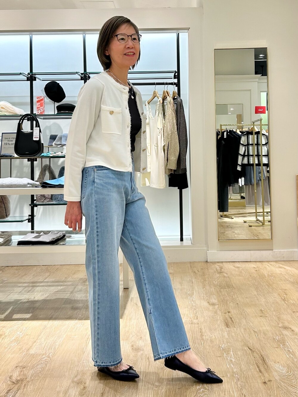 ブルー系のデニムパンツ、ホワイト系のカーディガン/ボレロ、グレー系のTシャツ/カットソーを着用したレディースの冬コーディネートの5枚目の写真