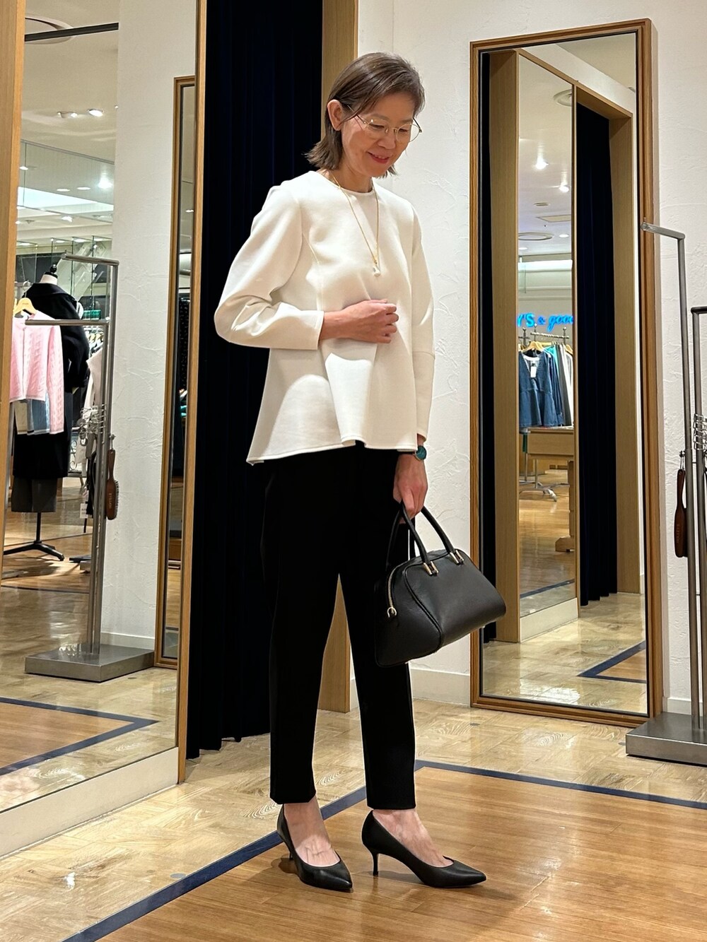 ブラック系のその他パンツ、ブラック系のショルダーバッグ、ホワイト系のTシャツ/カットソーを着用したレディースの冬コーディネートの5枚目の写真