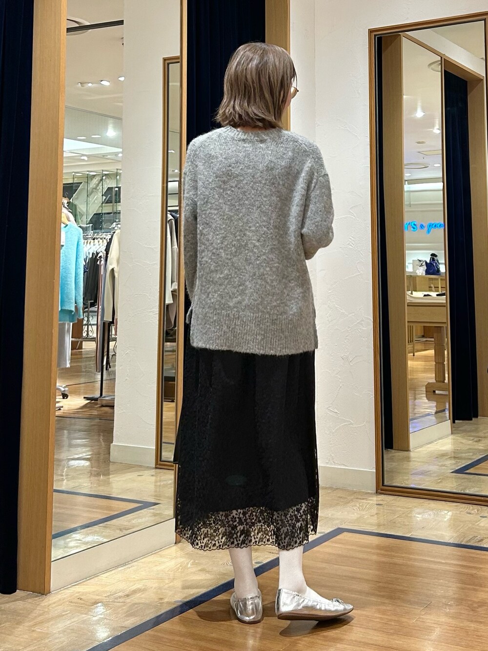 グレー系のニット/セーター、ブラック系のスカート、ブラック系のショルダーバッグを着用したレディースの冬コーディネートの7枚目の写真