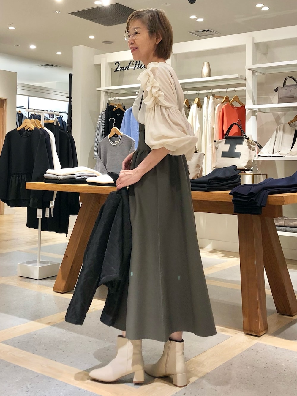 ホワイト系のシャツ/ブラウス、グレー系のスカート、ブラック系のブルゾンを着用したレディースの秋コーディネートの5枚目の写真