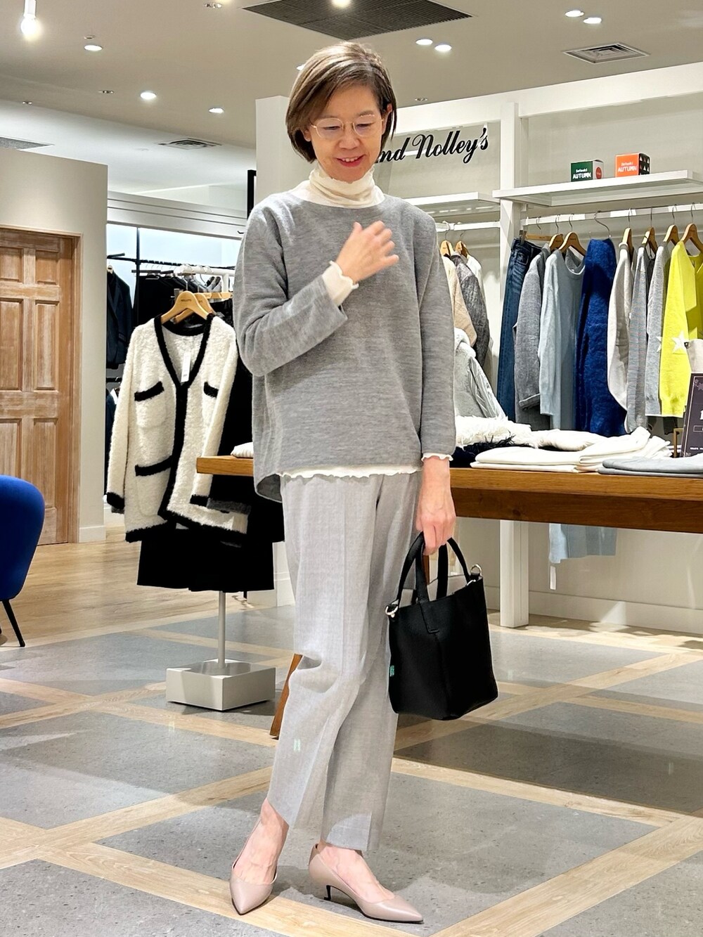 グレー系のその他パンツ、ブラック系のトートバッグ、グレー系のニット/セーターを着用したレディースの秋コーディネートの2枚目の写真
