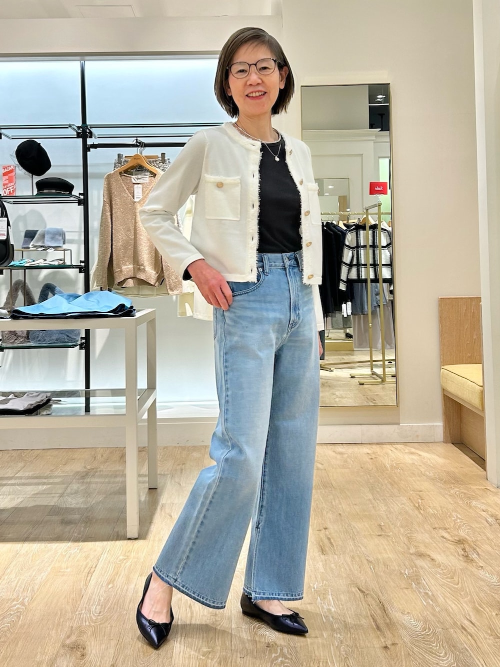 ブルー系のデニムパンツ、ホワイト系のカーディガン/ボレロ、グレー系のTシャツ/カットソーを着用したレディースの冬コーディネートの3枚目の写真