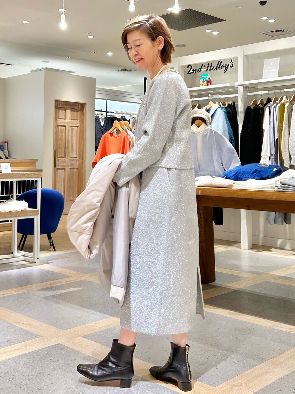 シルバー系のスカート、シルバー系のニット/セーターを着用したレディースの秋コーディネートの7枚目の写真