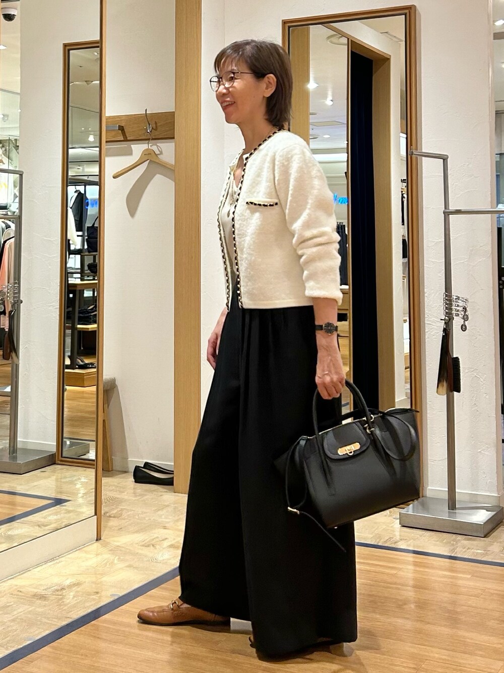 ブラック系のその他パンツ、ブラック系のショルダーバッグ、ホワイト系のカーディガン/ボレロを着用したレディースの秋コーディネートの5枚目の写真